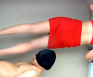 Oszałamiająca chinki kochanki w seksownym czerwonym stroju daje szorstkie stymulacje butami i stymulacja stopami